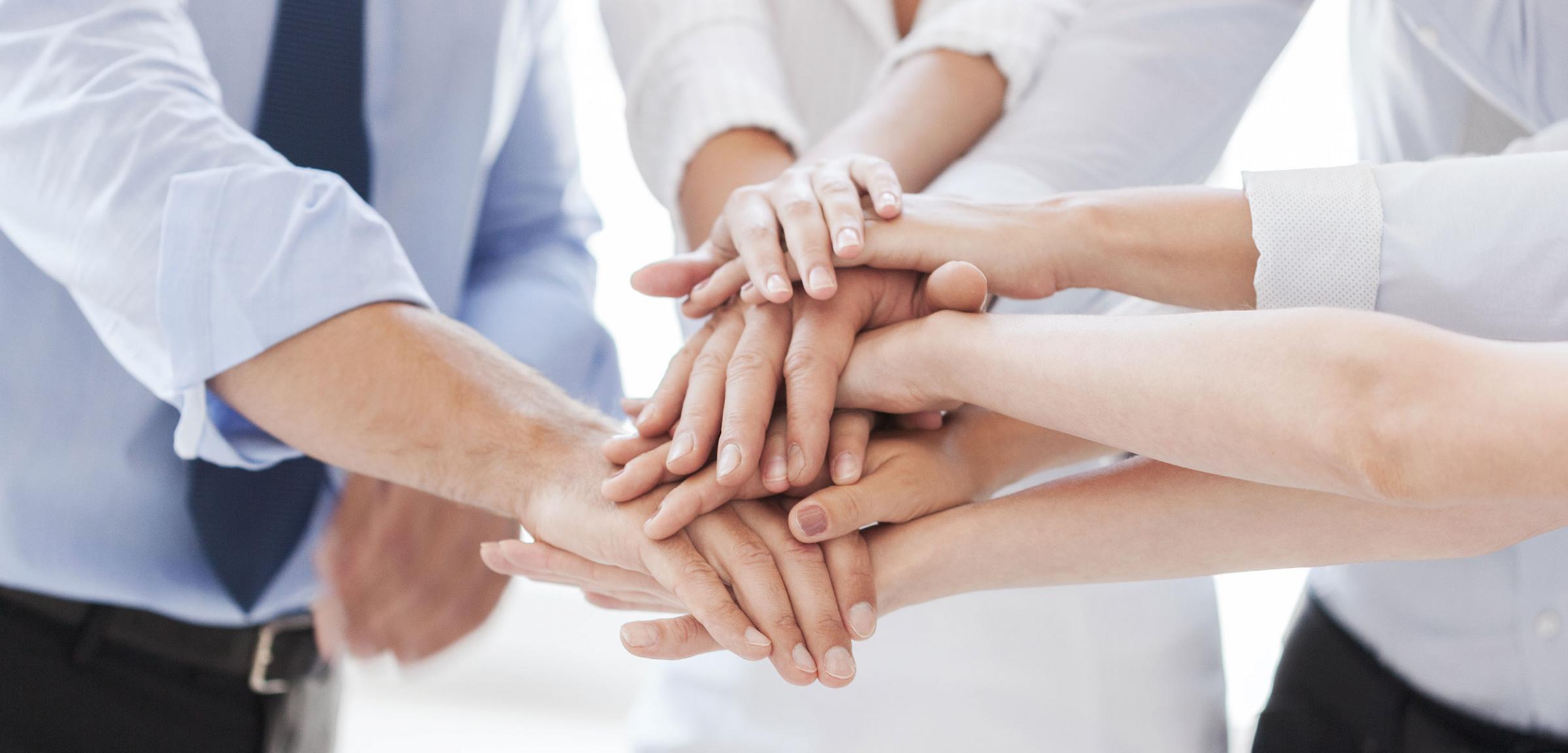 Four people with hands stacked on each other